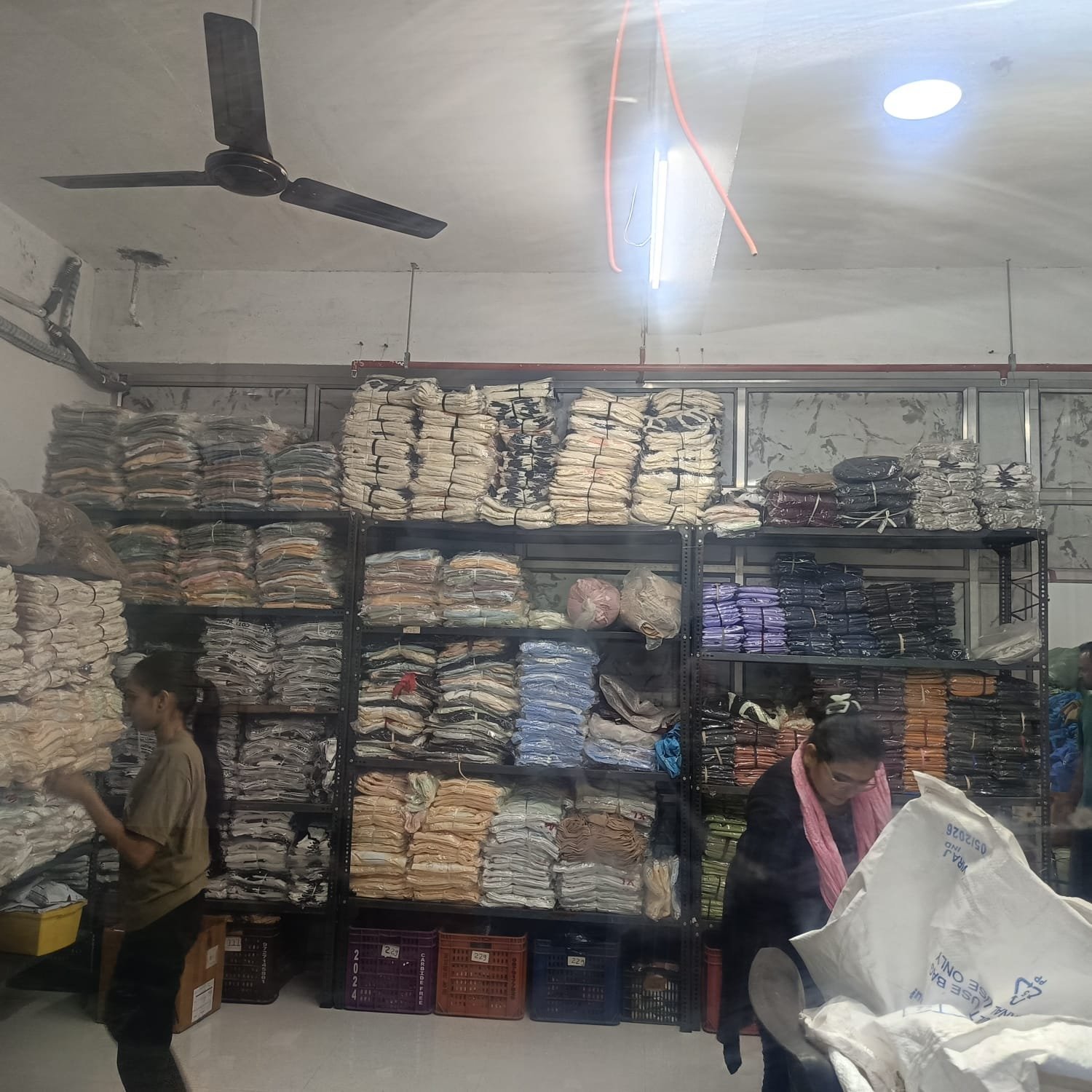 Folded and bundled stock sorted on shelving at the J B International facility